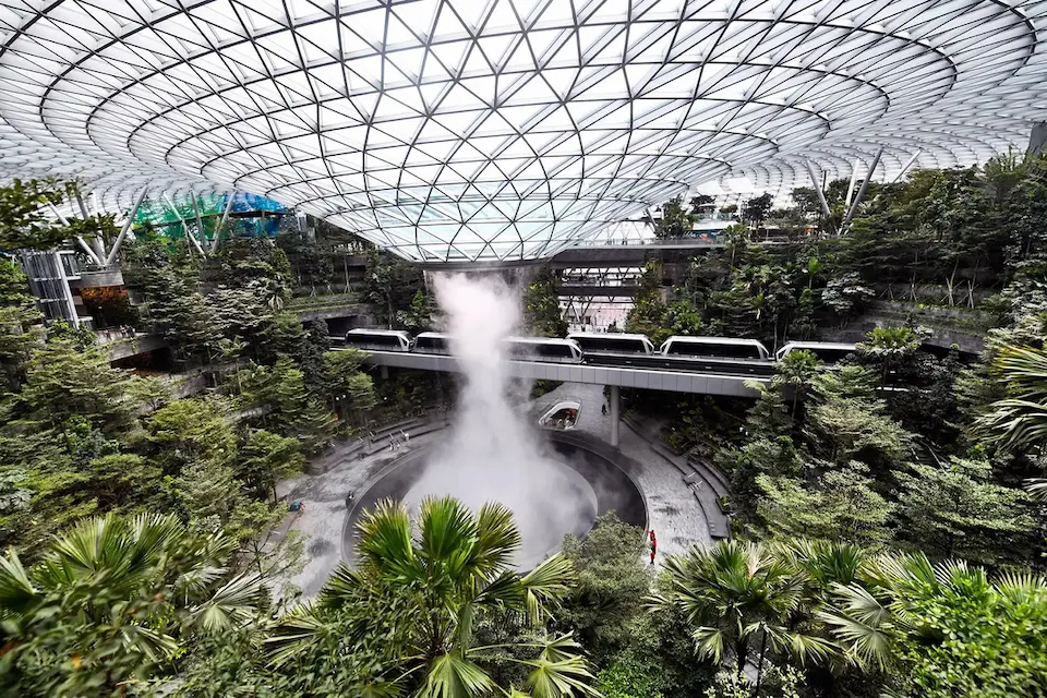 «آبشار سرپوشیده Jewel Changi در فرودگاه چانگی سنگاپور، میان فضای سبز استوایی و مسیر قطار»
